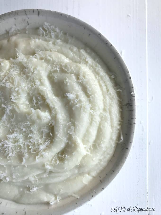 Close up of a white bowl filled with easy mashed cauliflower. 