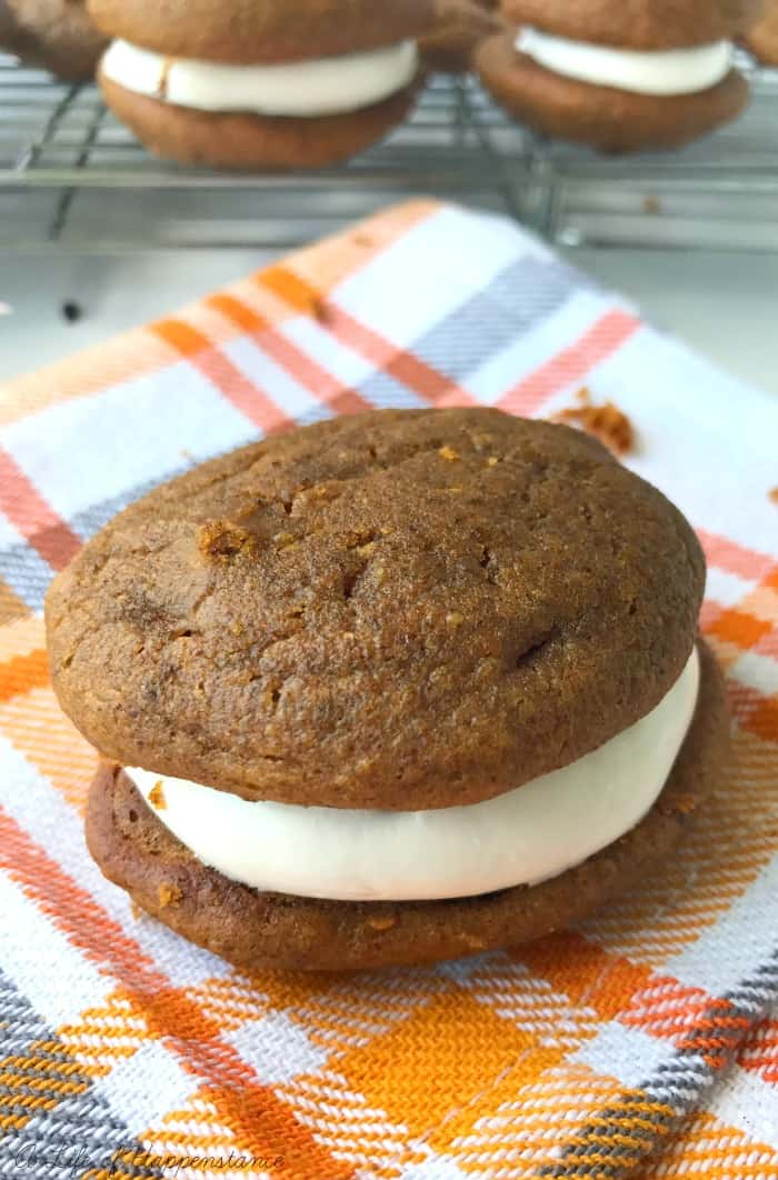 A whoopie pie on a checkered tea towel. 