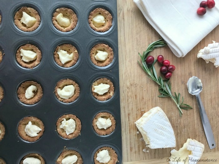 Filling the pre baked tartlets with brie cheese. 