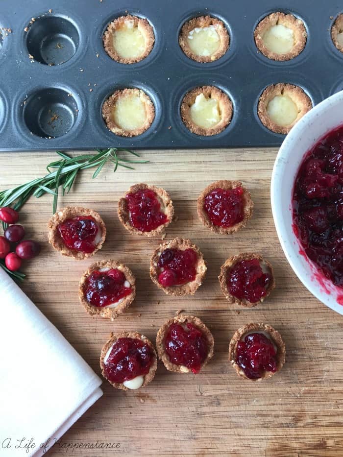 Cranberry tartlets on a wood cutting board. 