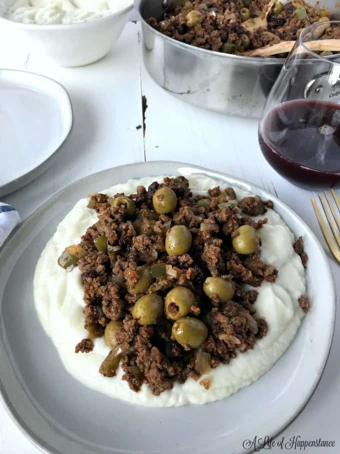 Easy Cuban picadillo served over a plate of mashed cauliflower. 
