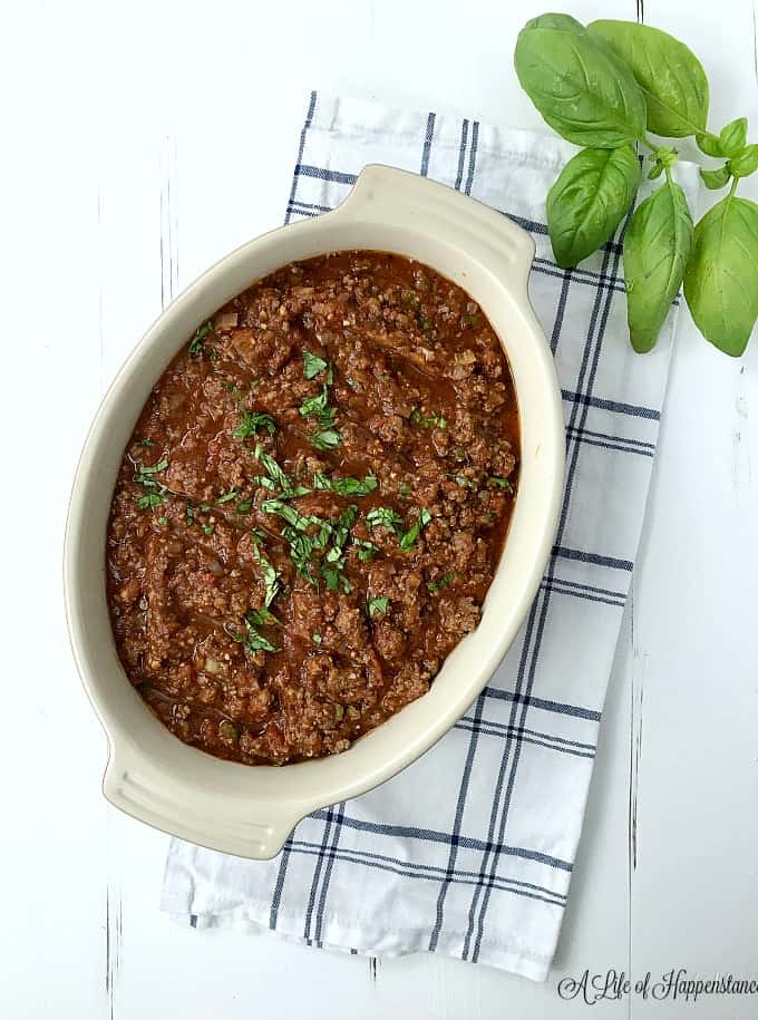 Meat sauce in a cream serving dish on a white table. 