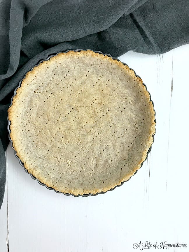 A baked tart crust on a white table. 