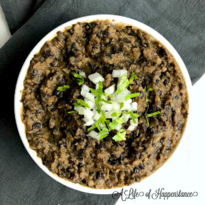 Refried black beans in a white bowl.