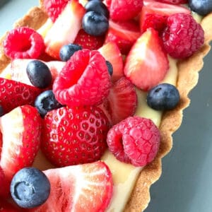An almond flour lemon tart topped with fresh berries.